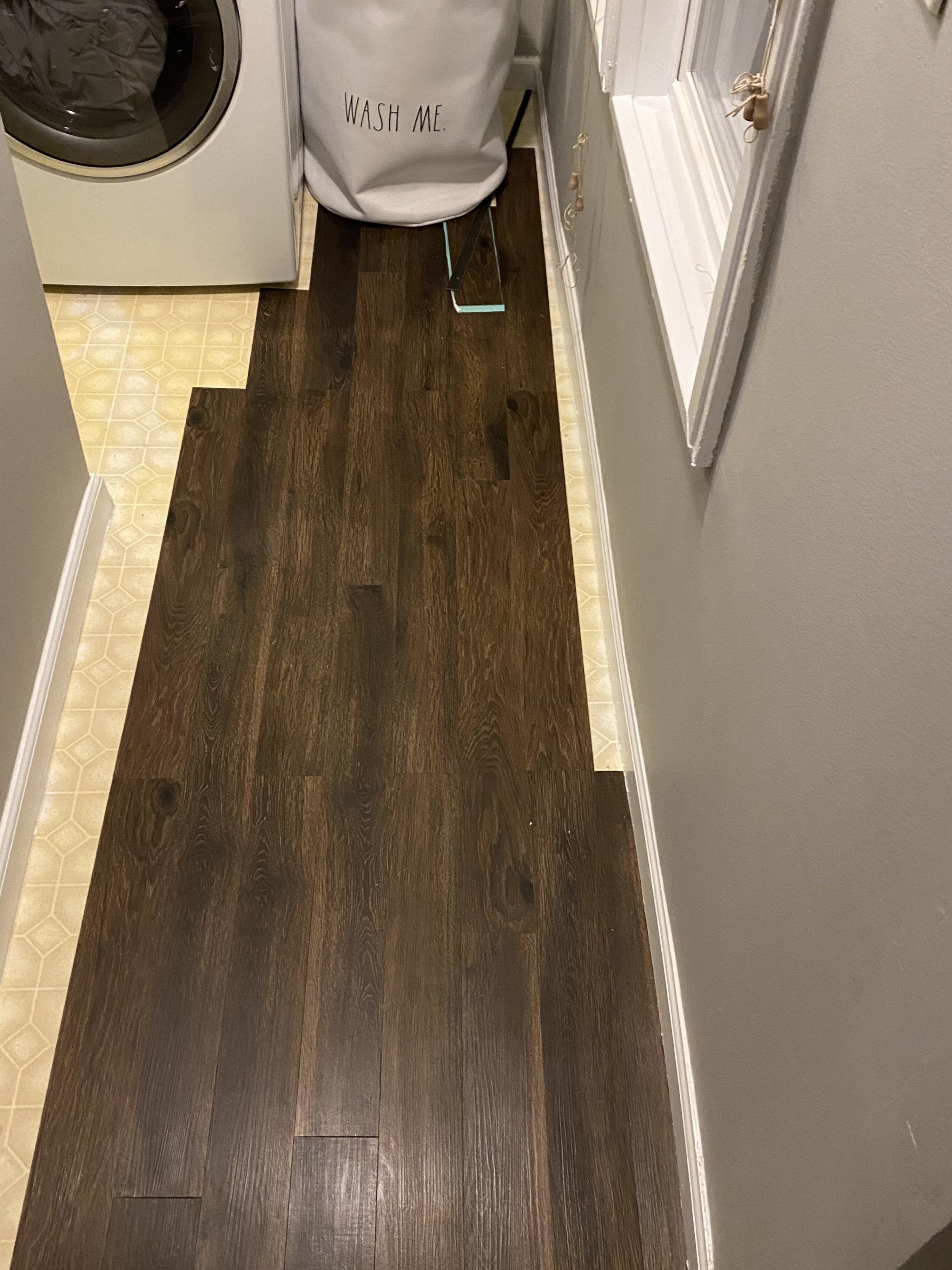 sections of wood vinyl plank laid down in a bathroom on top of tile