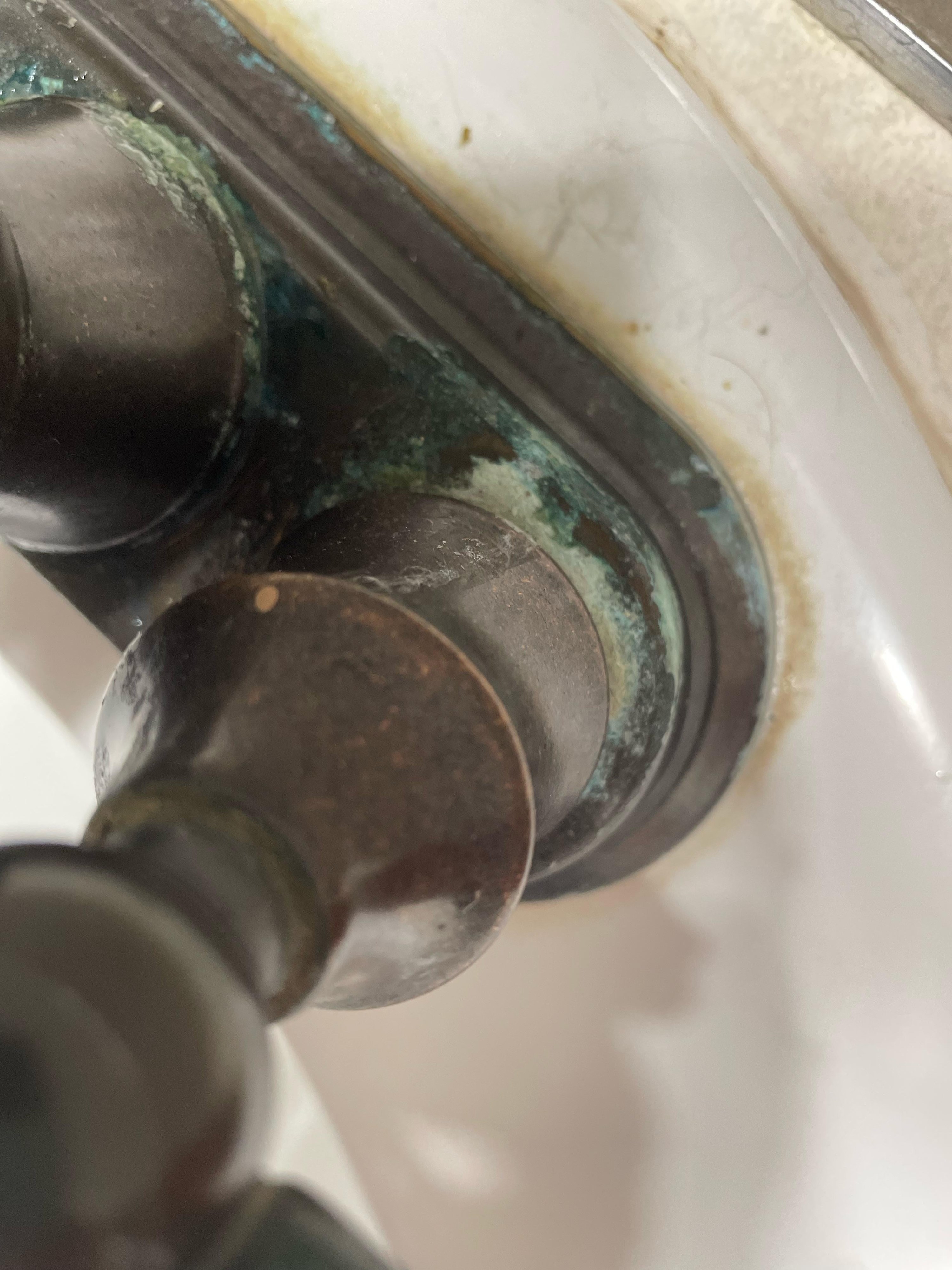 rust and deposits on a copper faucet on bathroom sink