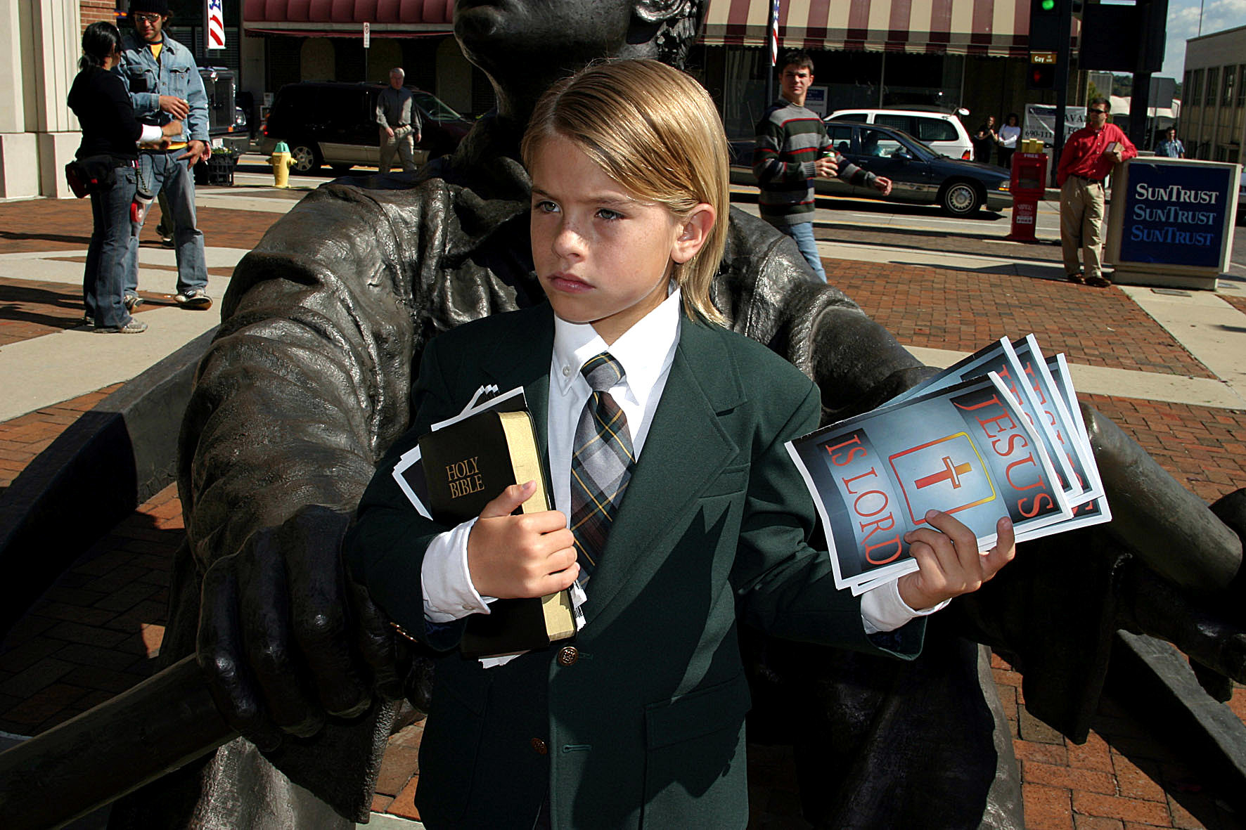 A young boy holding the Bible and religious pamphlets