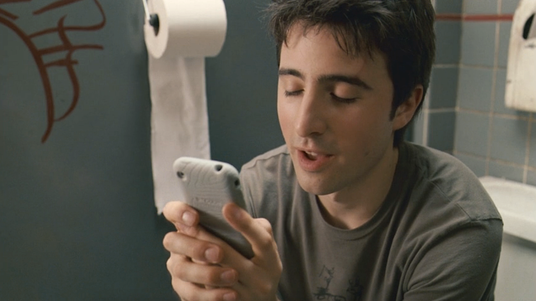 A person on the toilet on the phone