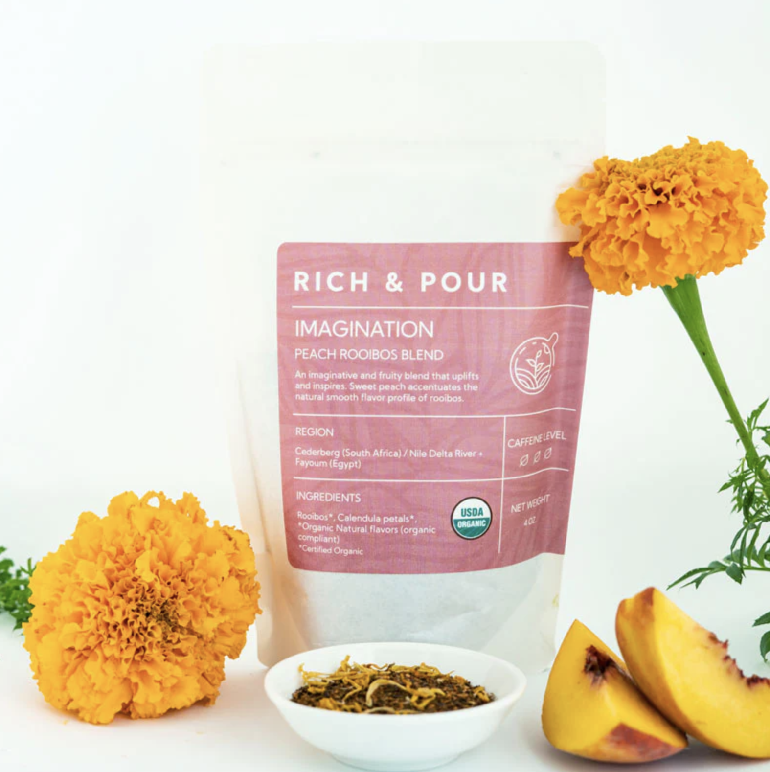 Package of Peach Rooibos Blend next to tea leaves and peaches