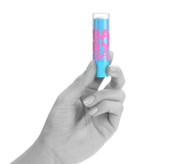 A person holding a tube of lip balm