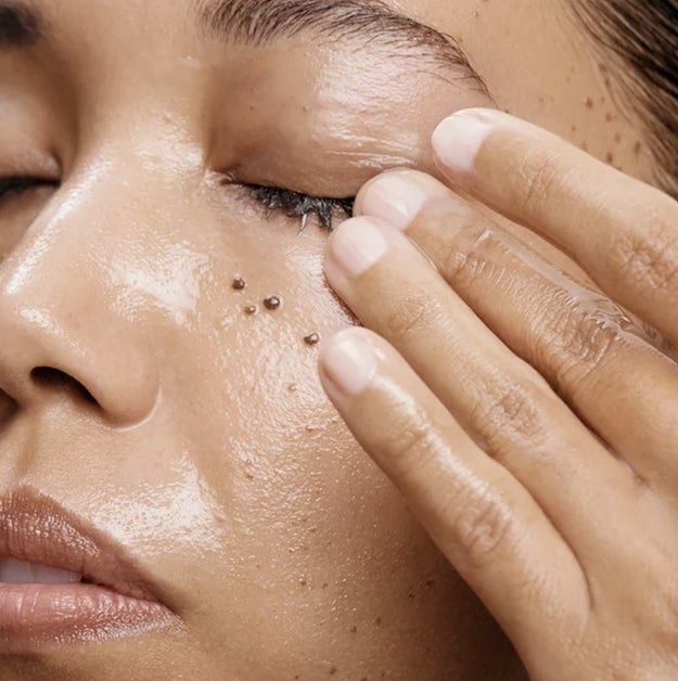 A person rubbing cleansing balm on their face