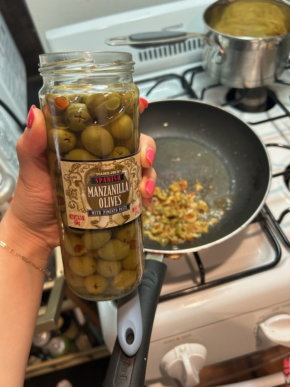 The writer holding a jar of olives