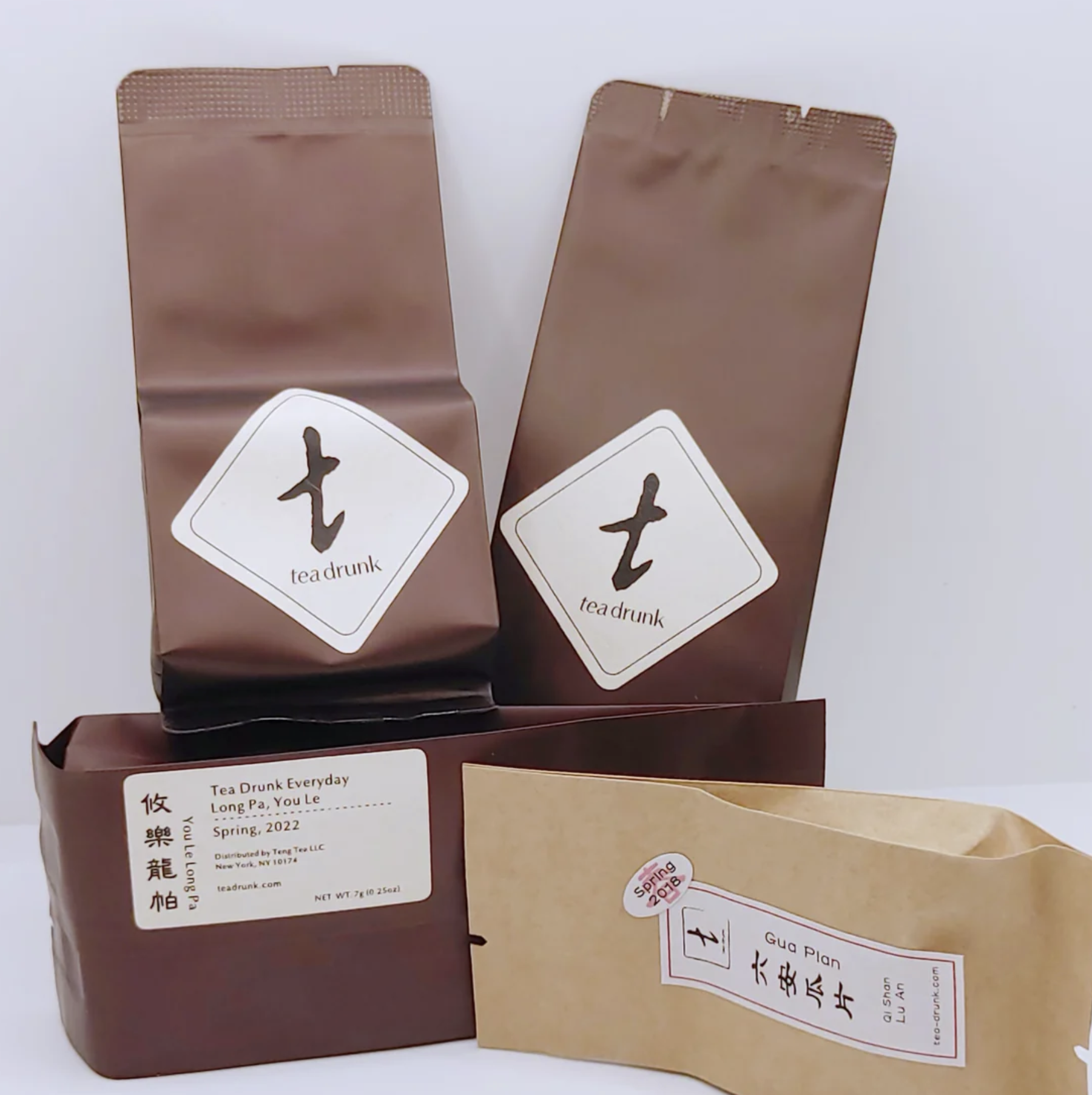 Four bags of tea sitting on top of each other.