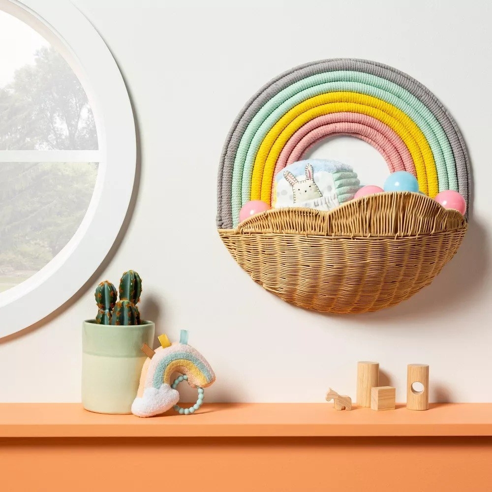 The storage basket with a rainbow above it hanging on a wall