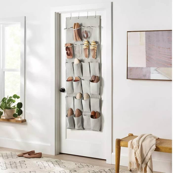 The shoe organizer hanging over a door with shoes inside