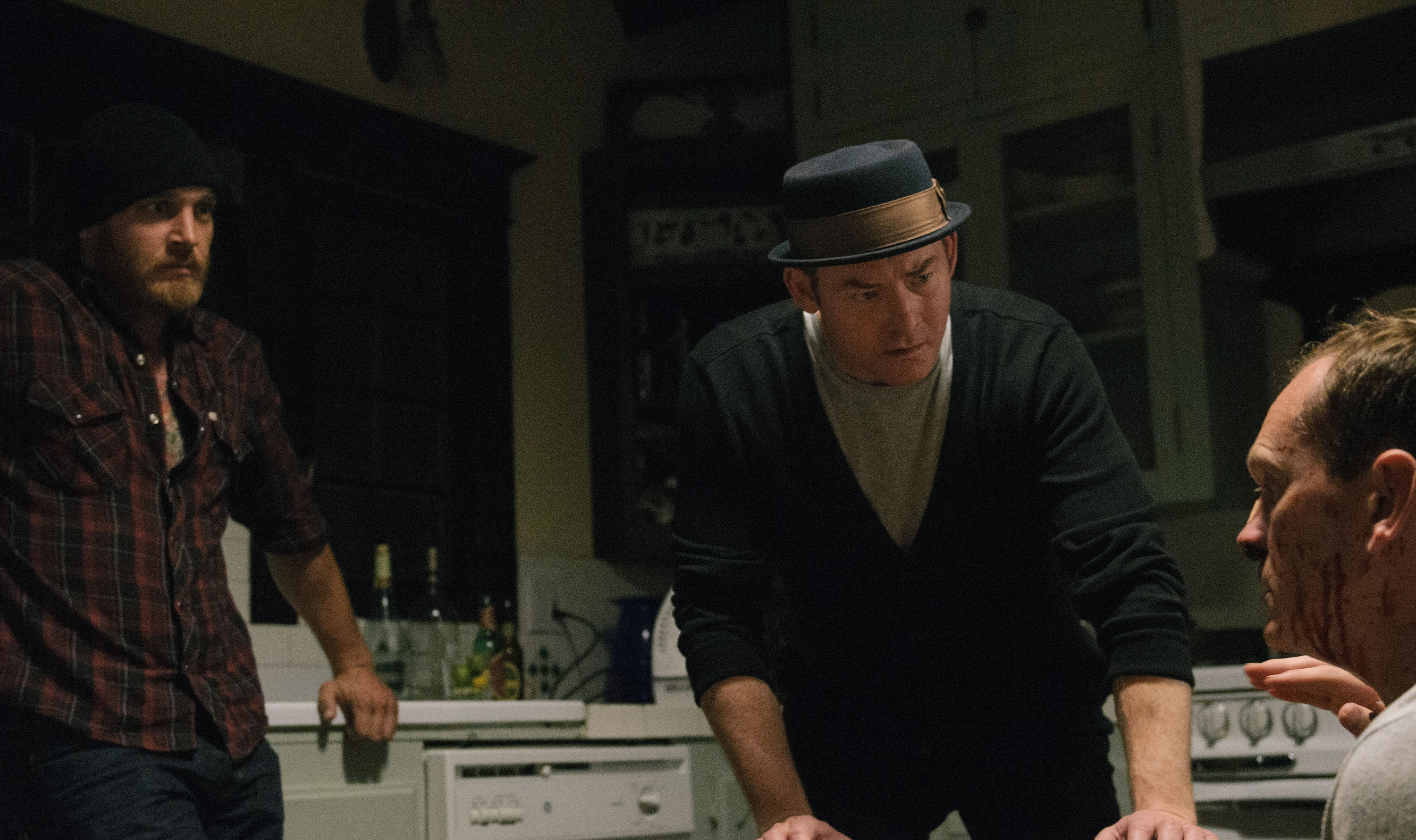 Ethan Embry and David Koechner stare pensively at a bloody Pat Healy