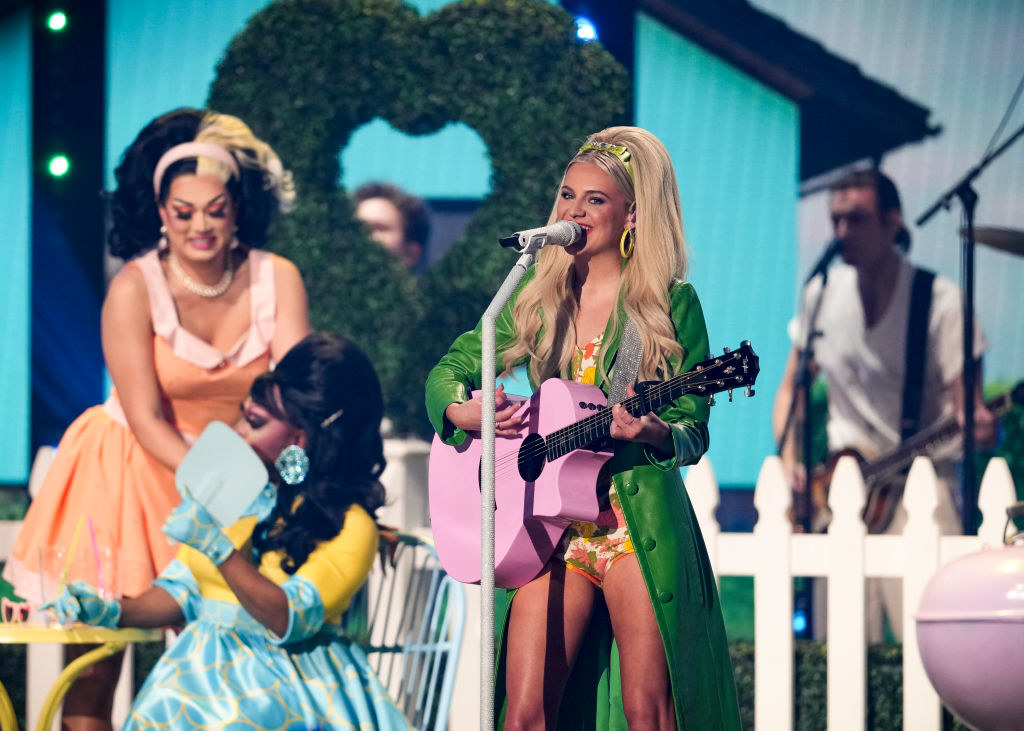 Kelsea performing onstage with the drag stars