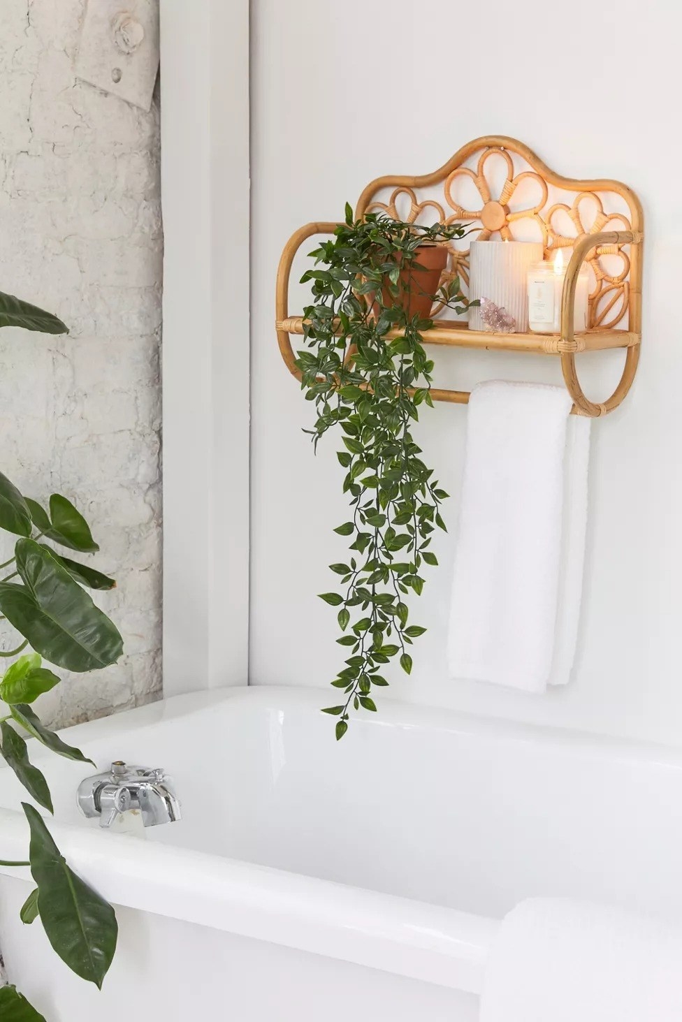 the wall shelf above a bathtub with candles and a towel on it