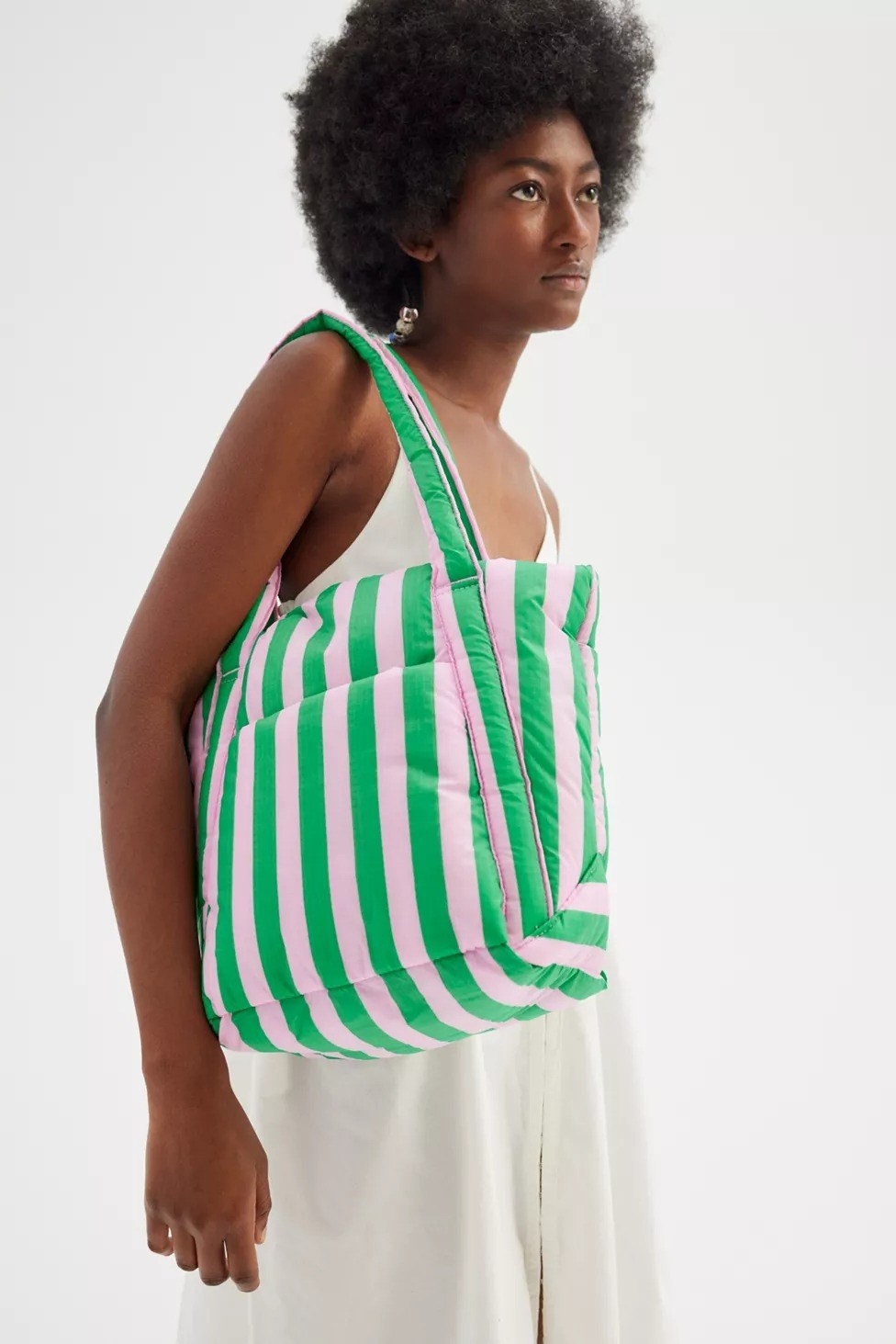 model carrying the tote in green and pink stripes