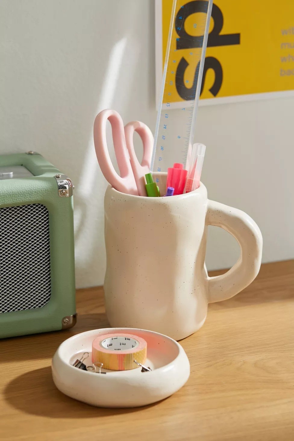 the white mug and coaster set with desk supplies on it