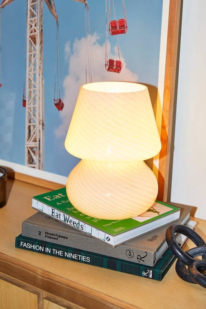 the white glass lamp on books
