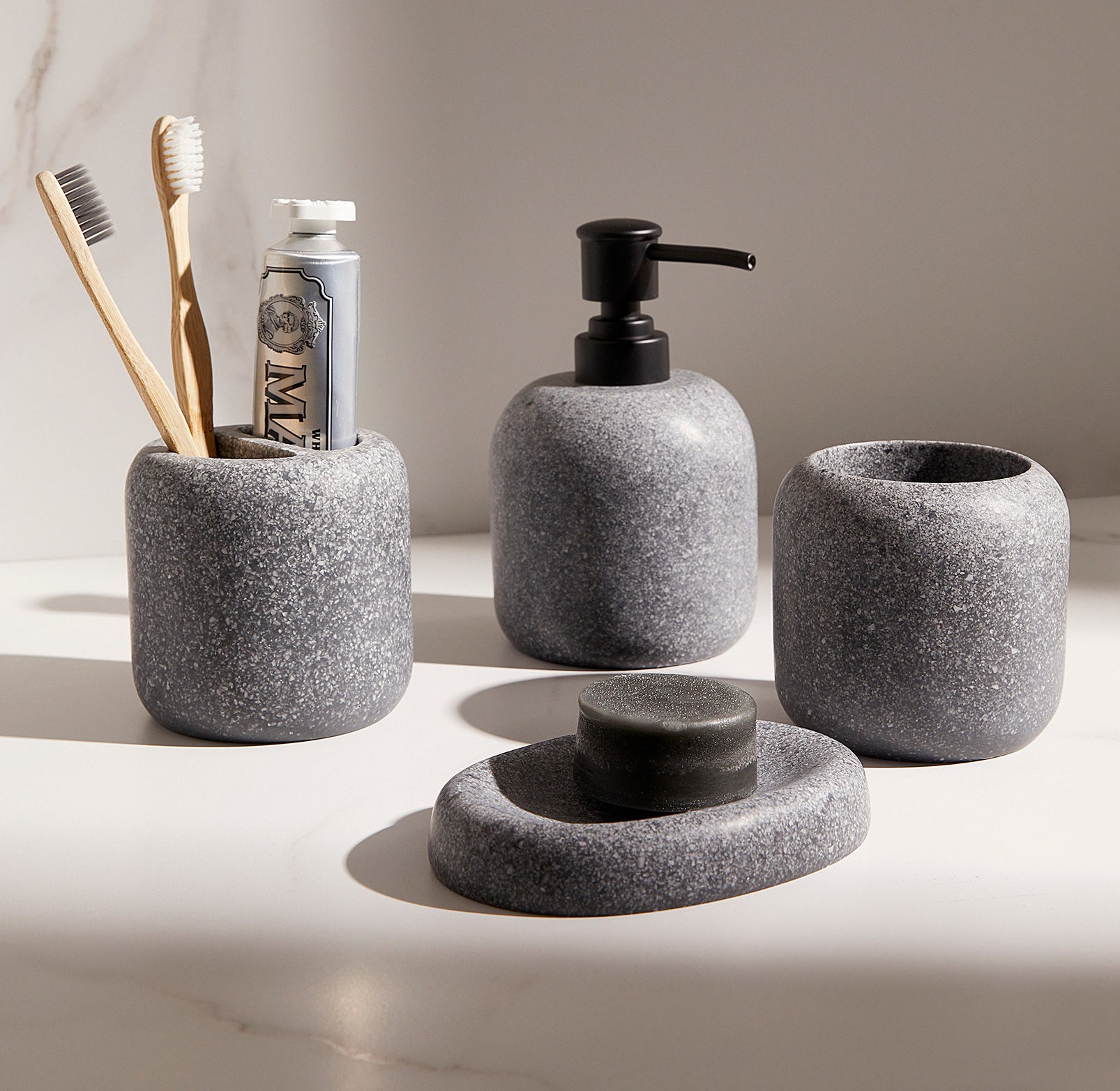 a four piece set of stone-like bathroom accessories