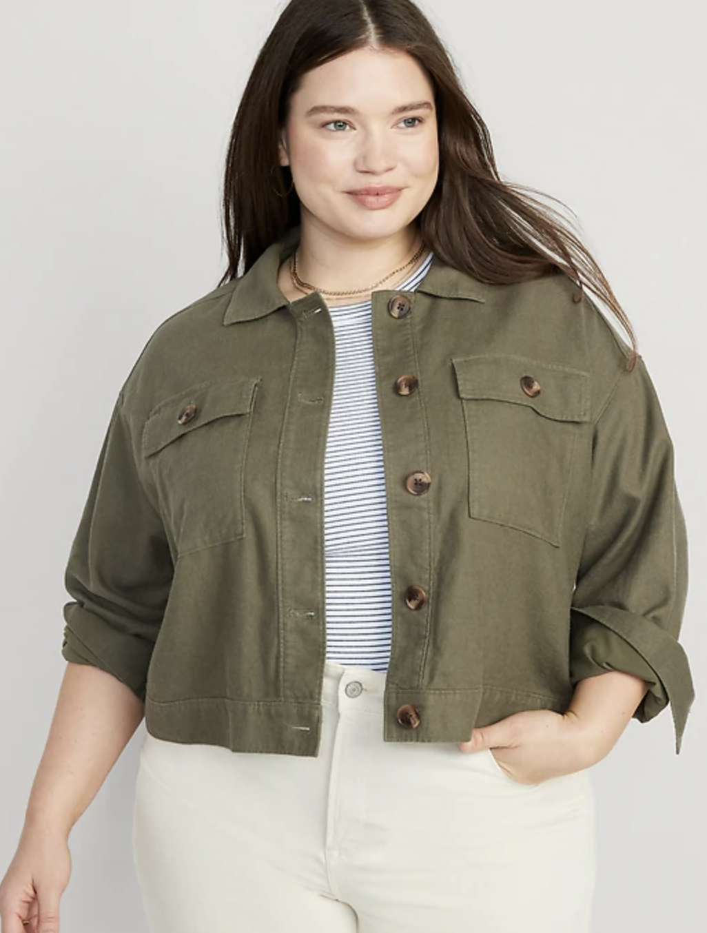 a model wearing the jacket over a striped shirt