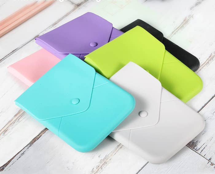 a set of different coloured silicone pouches on a wooden surface