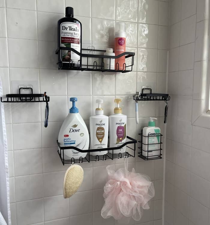 a reviewer photo of the black wire containers in a white tile shower