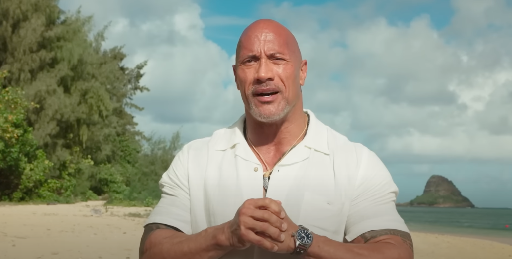 A close-up of Dwayne speaking on the beach