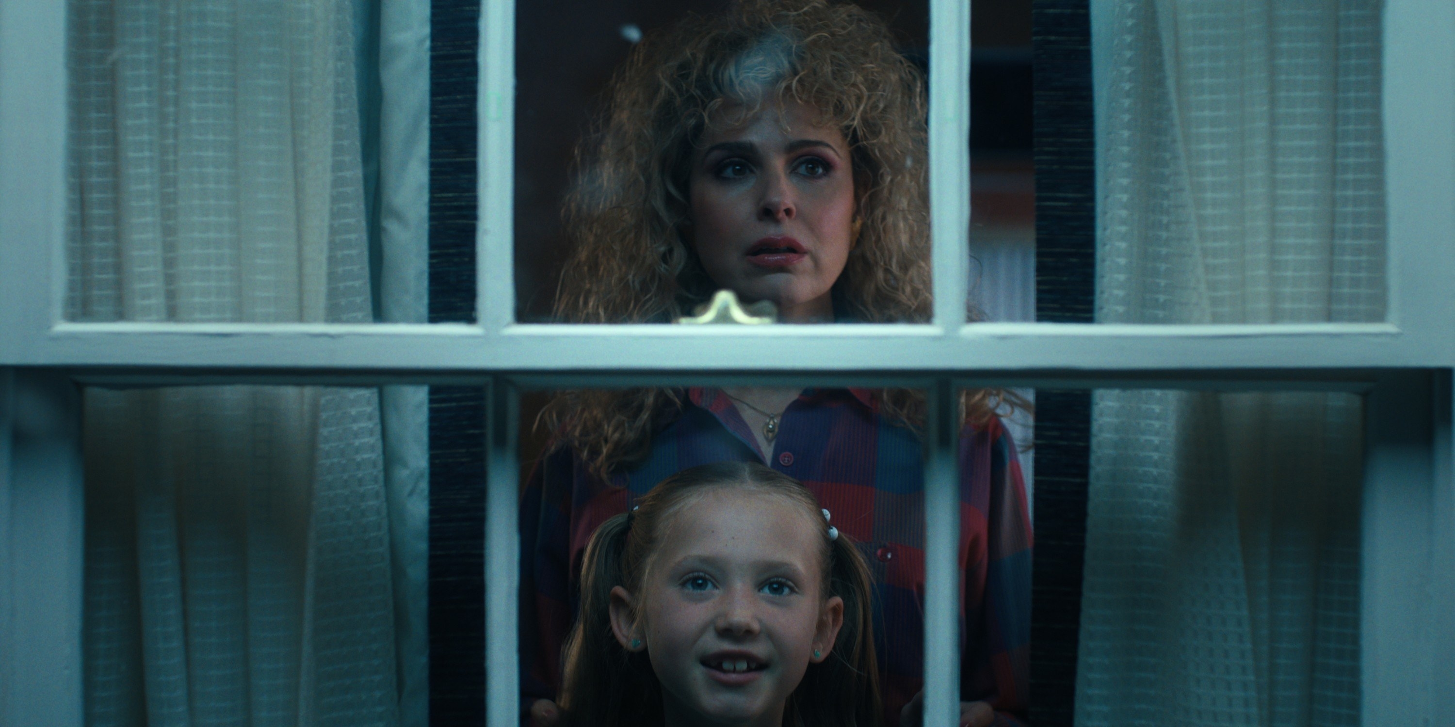 Cara Buono and a little girl looking out the window in Stranger Things