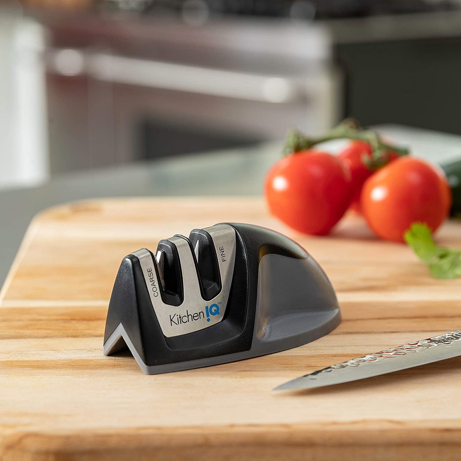 stock photo showing the knife sharpener resting on a cutting board next to a knife