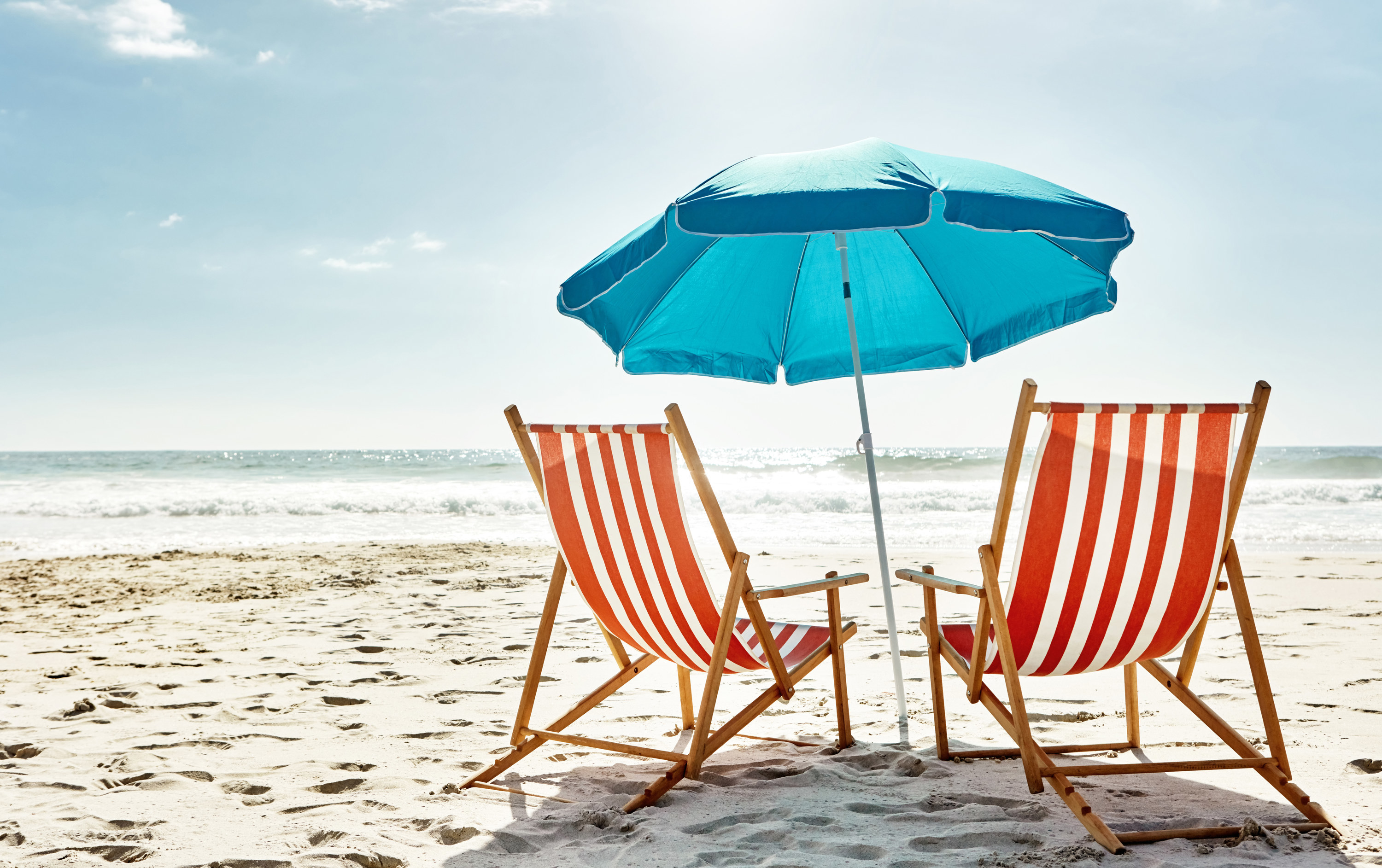 Бюджетно отдохнуть летом. Шезлонг на пляже. Лежак на море. Зонтик на пляже. Пляжный зонтик и шезлонг.