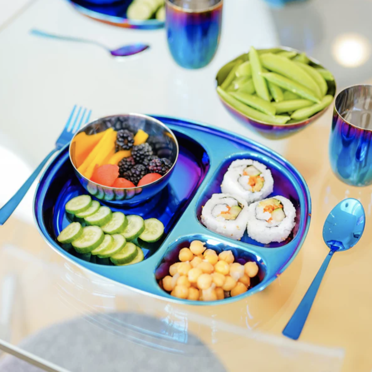 Portioned plate with fruit, sushi, and corn