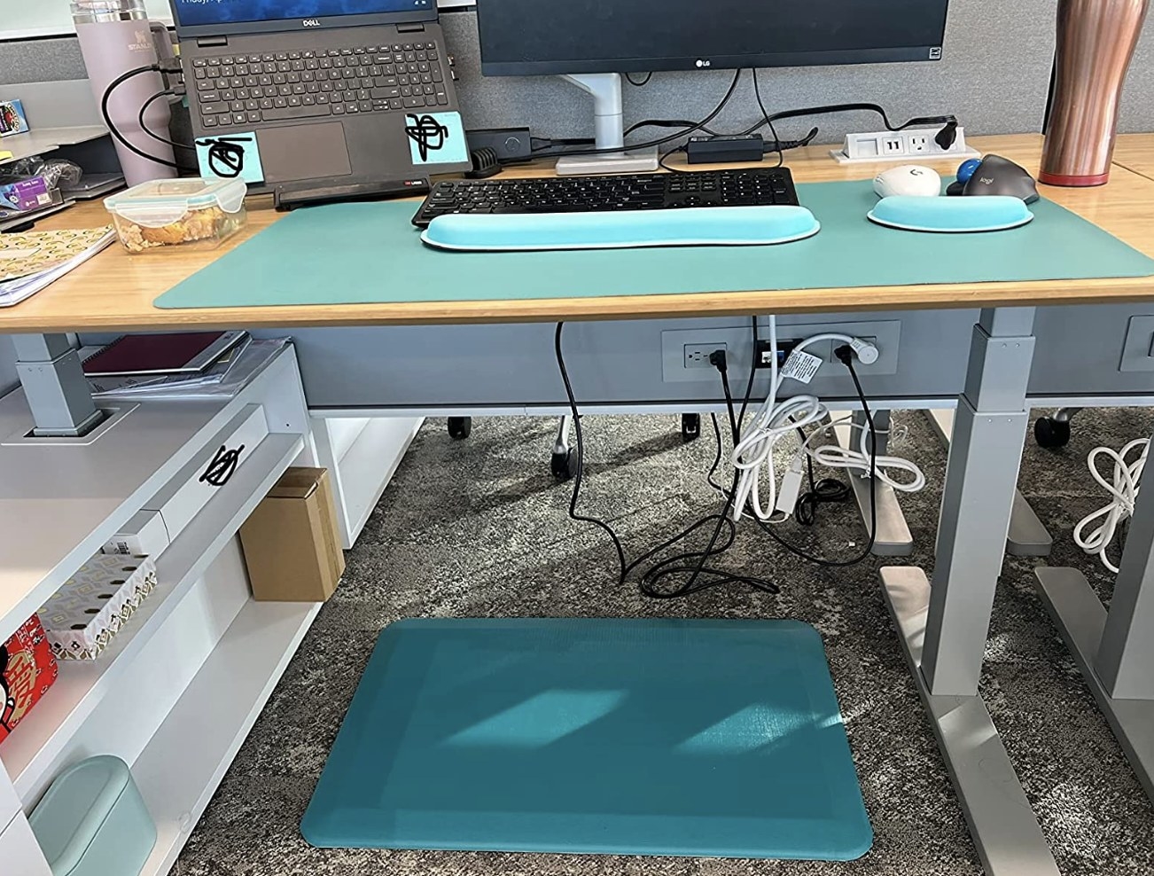 reviewer showing their mat below their standing desk in blue