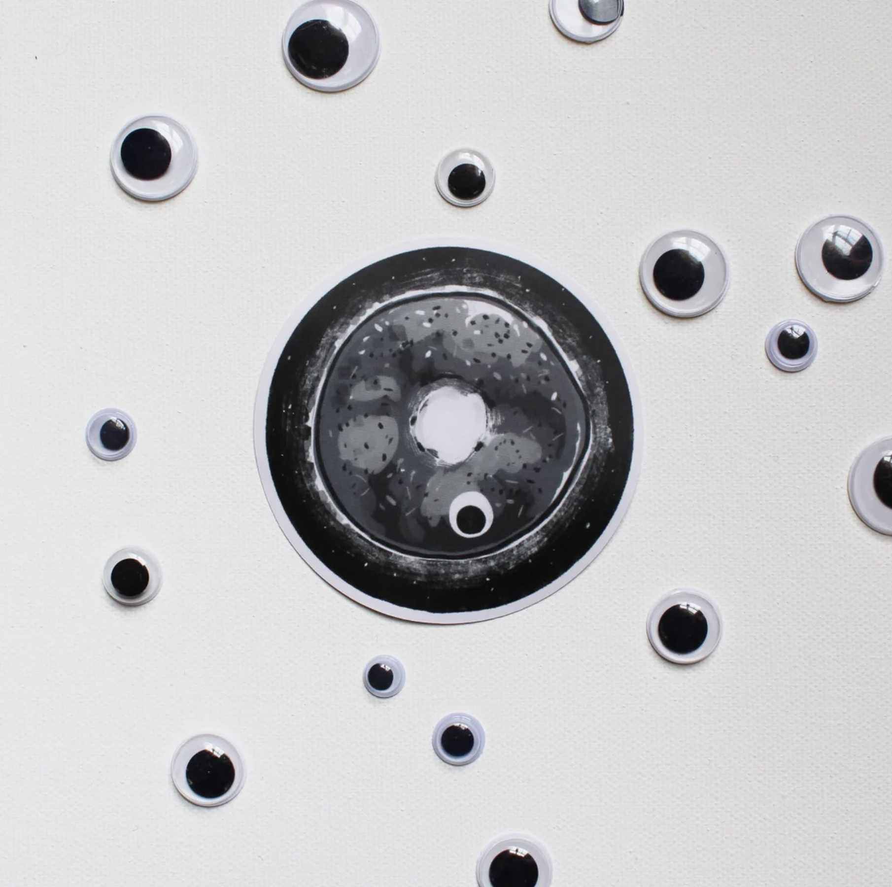 Everything Bagel sticker surrounded by googly eyes.