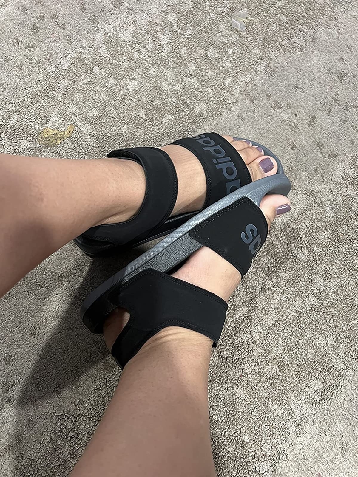 reviewer wearing the sandals in black and grey