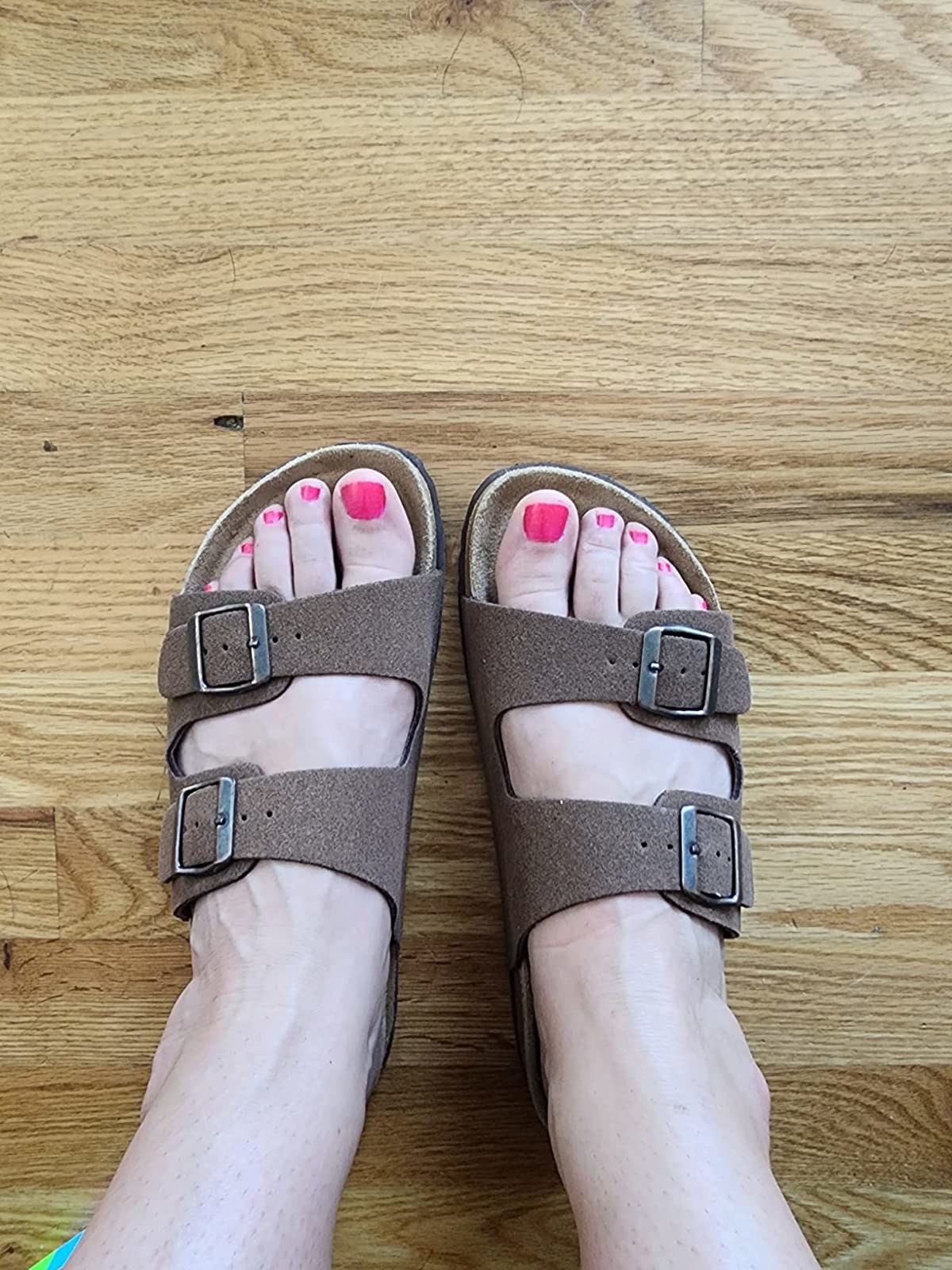 reviewer wearing the sandals in brown vegan suede
