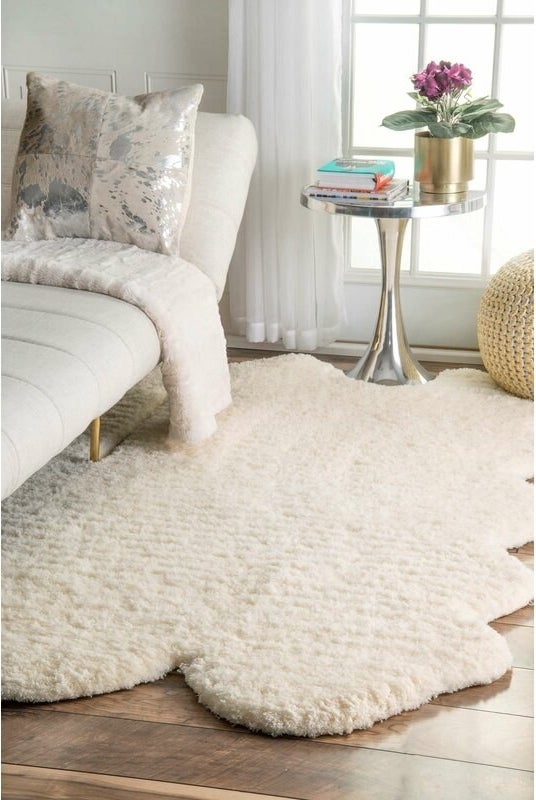 the off white rug on the floor in front of a chaise