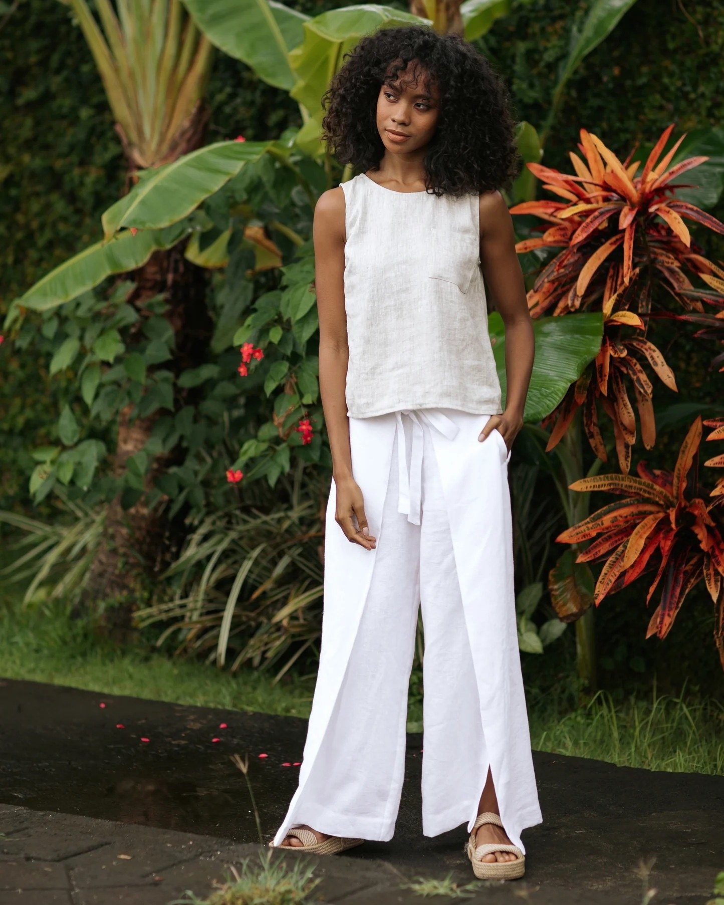 A model wearing white pants with a white top and matching shoes