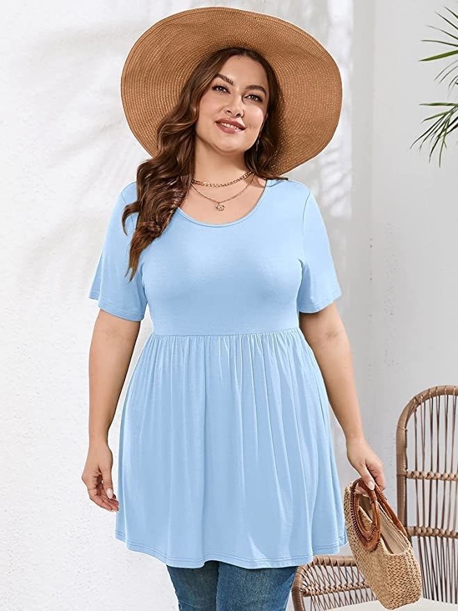 a model wearing the shirt with jeans and a sun hat