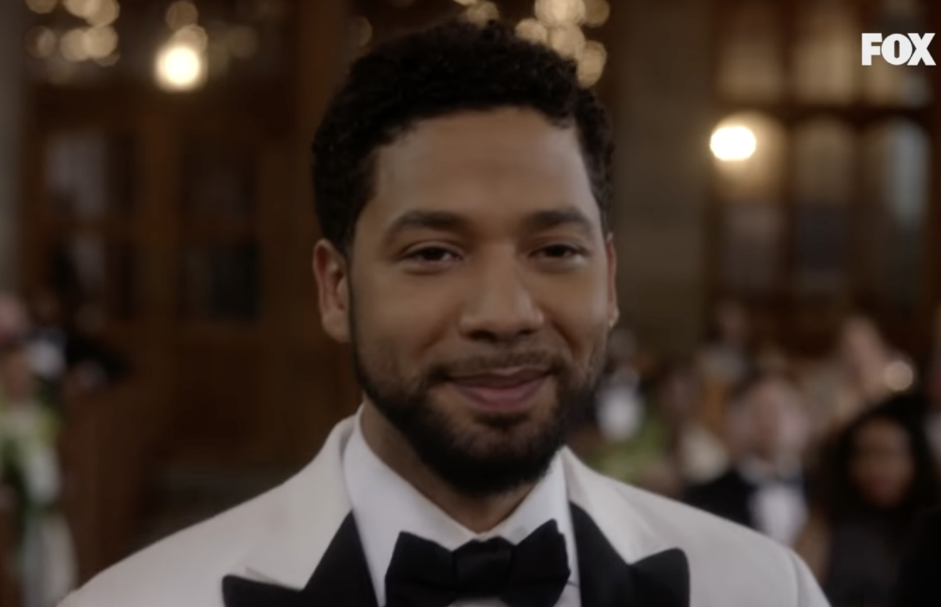 密切Jussie Smollett,选# x27;微笑和黑色领结穿着白色晚礼服