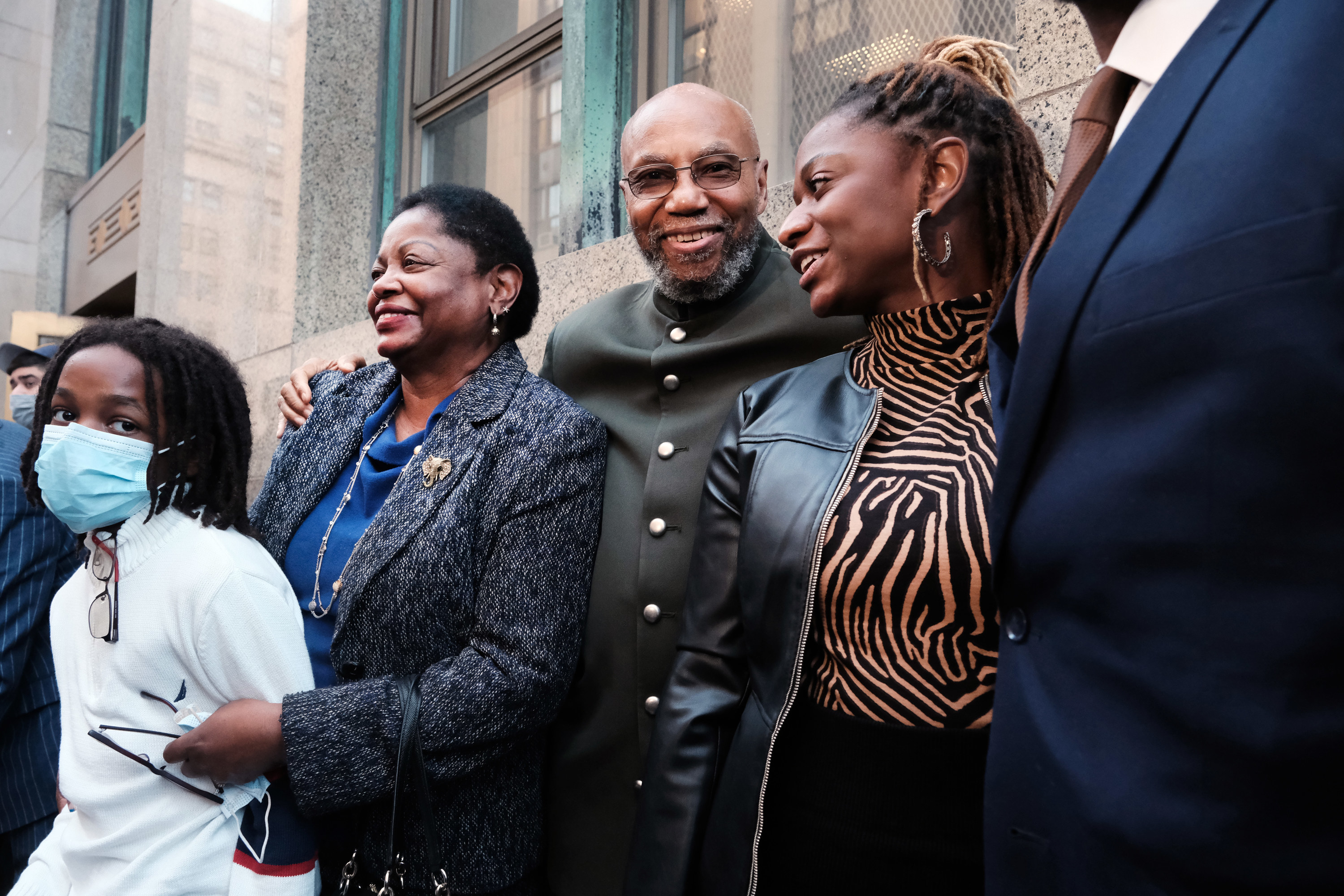 Muhammad Aziz stands outside of a New York City courthouse with members of his family and lawyers smiling after his release