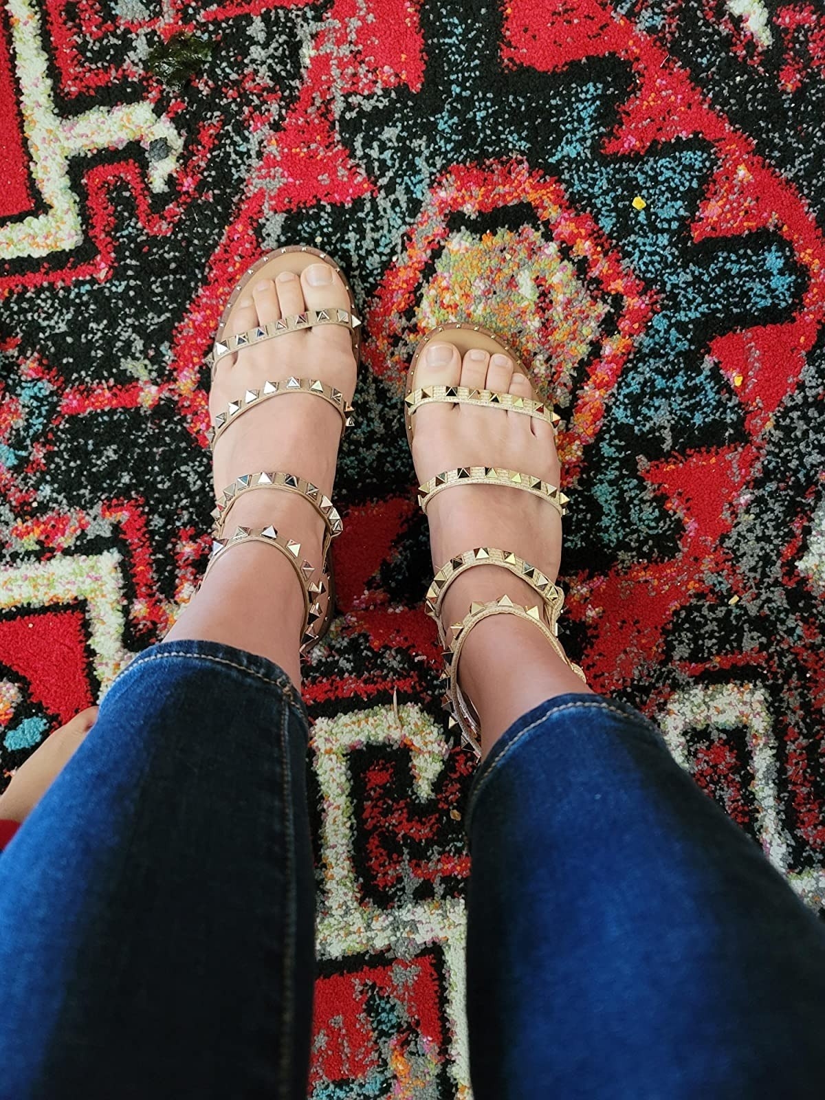 reviewer wearing gold-tone studded sandals
