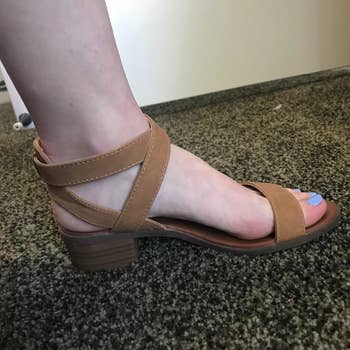 a reviewer wearing the sandals in brown