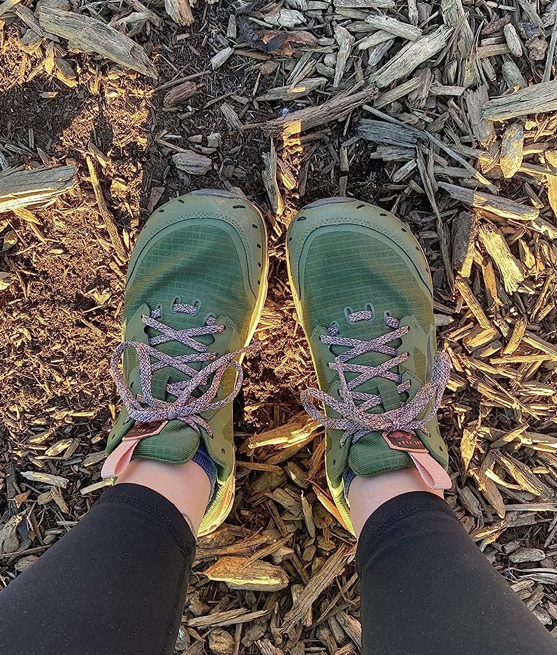 reviewer in green and pink alrea trail runners witha. wide toe box