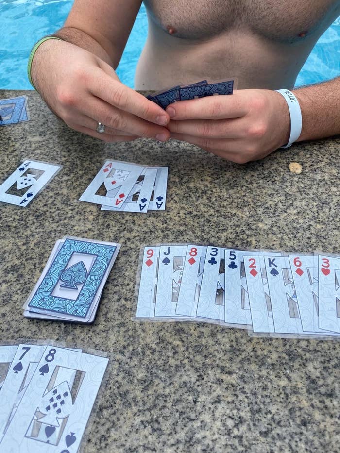 reviewer playing with the waterproof cards poolside