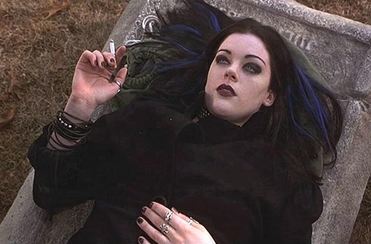 Erica Leerhsen lays on a tombstone and smoking a cigarette in Books of Shadows: Blair Witch 2