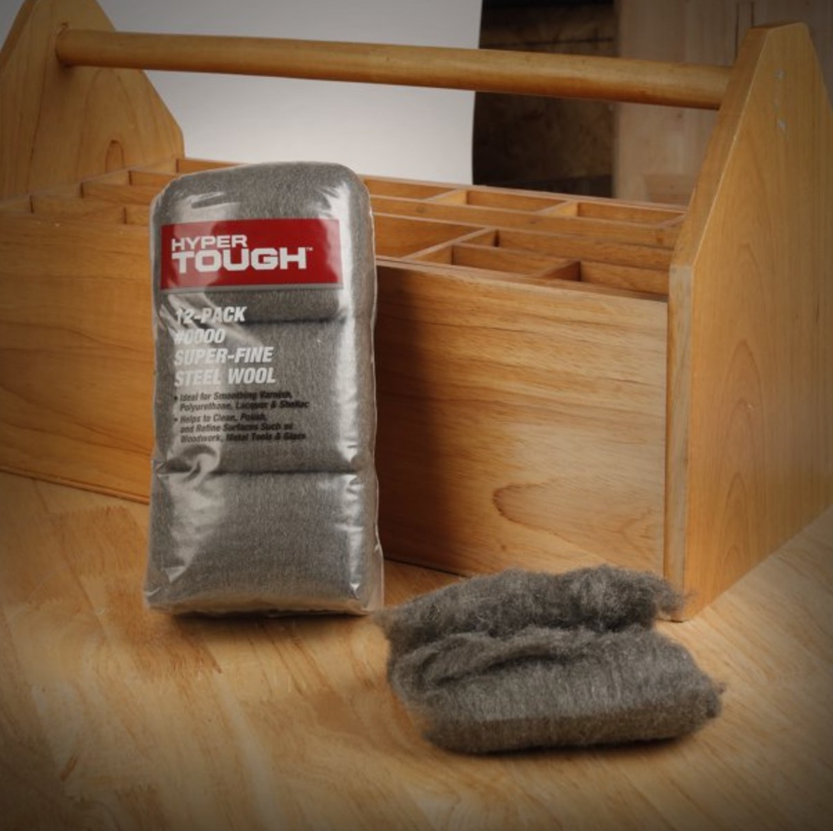 the silver steel wool in clear packaging in front of a wooden toolbox