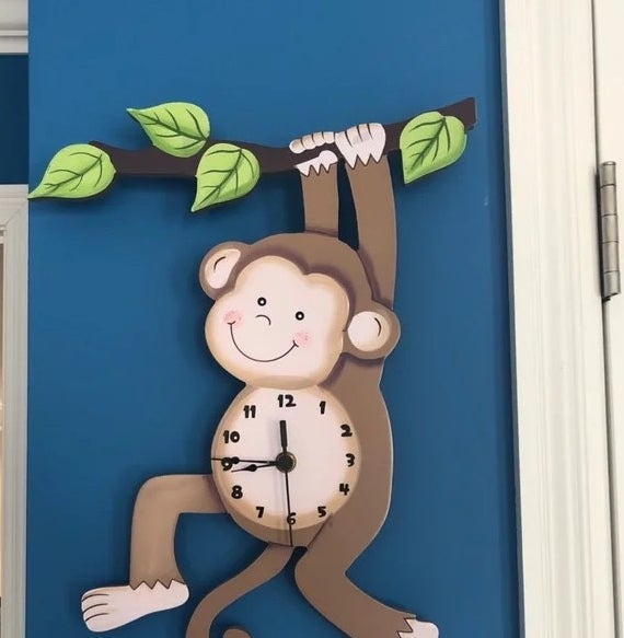 the monkey clock against a blue wall
