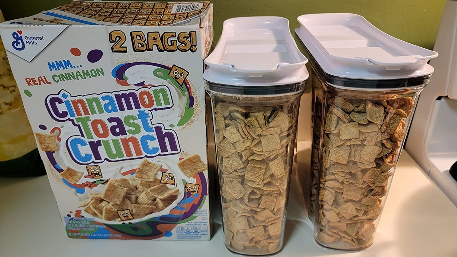 Reviewer image of two storage containers filled with cereal next to a box of cereal