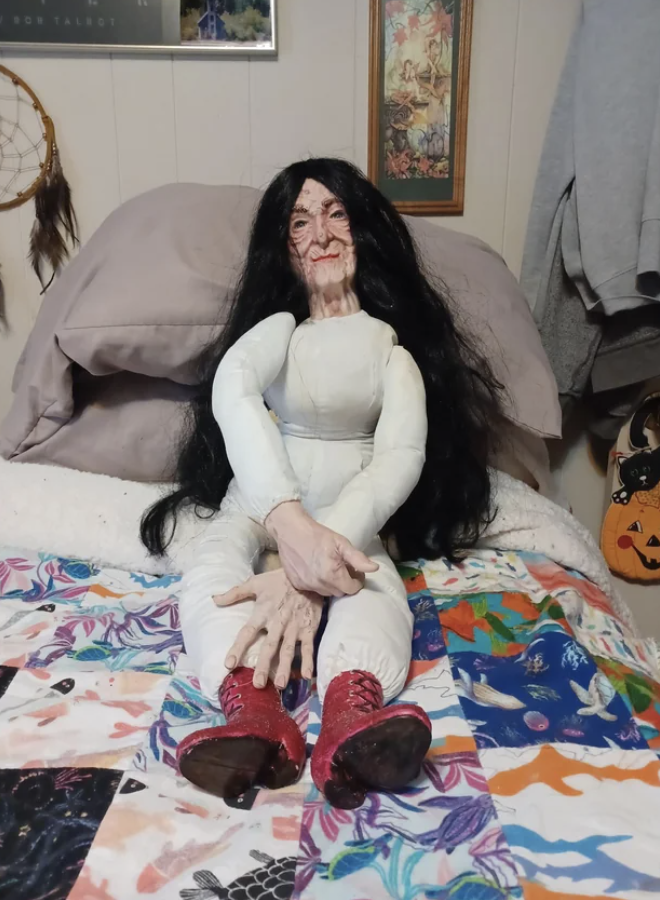 A creepy doll on a bed