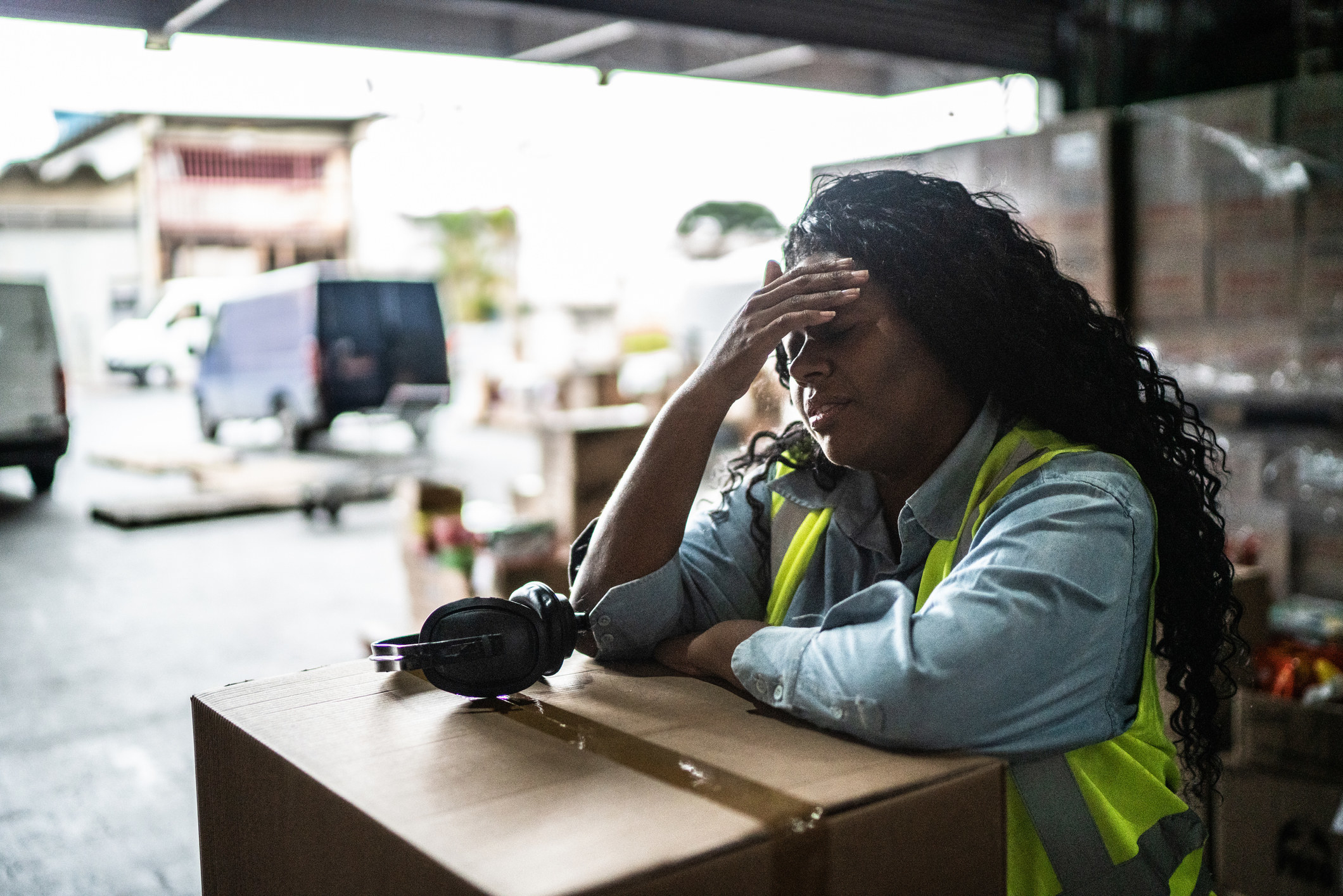 woman leaning on a box with her hand to her head