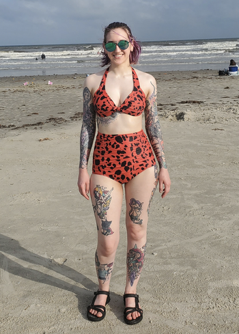reviewer wearing the swimsuit in the red and black print