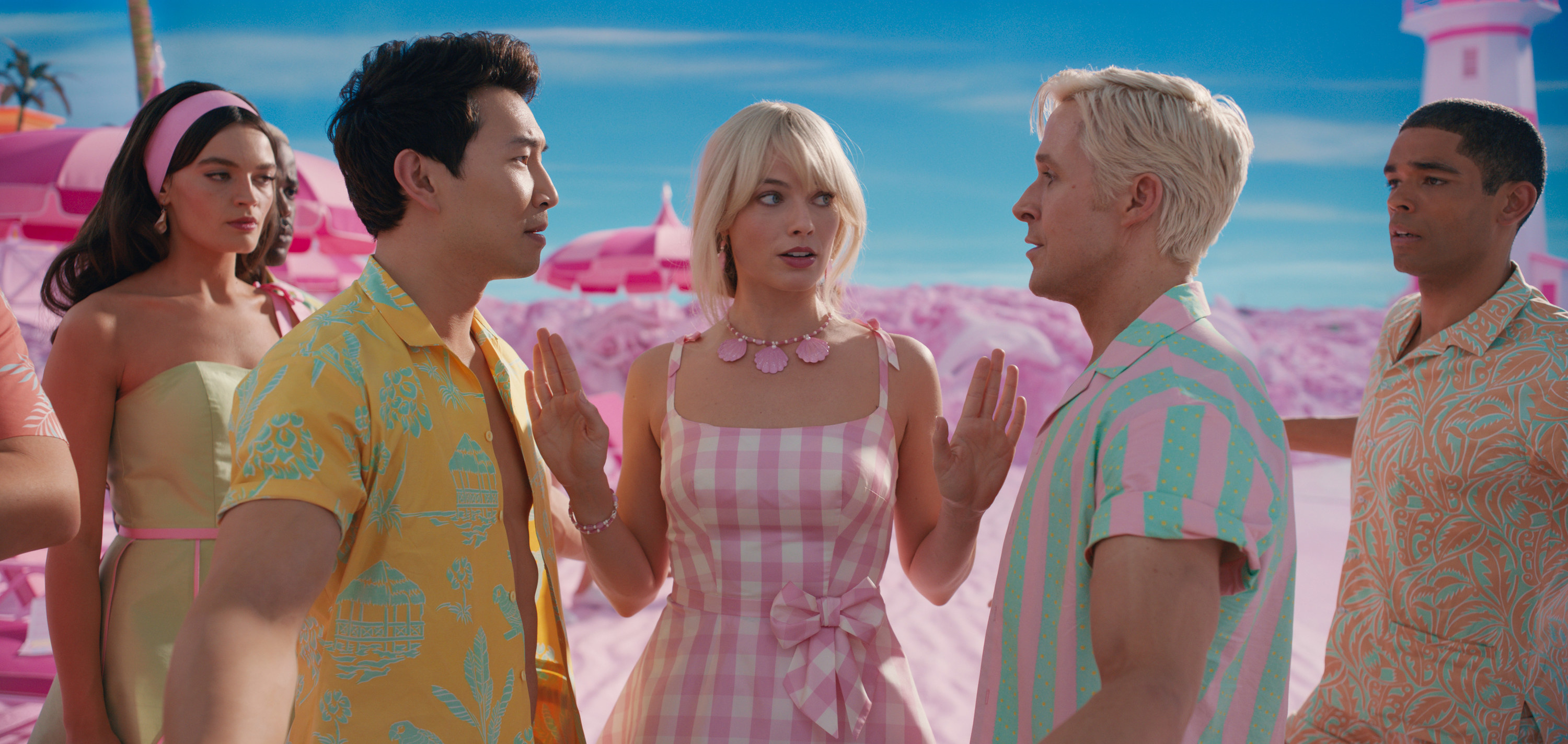 Margot as Barbie getting in-between Simu and Ryan as they argue with Emma Mackey and Kingsley Ben-Adir looking on