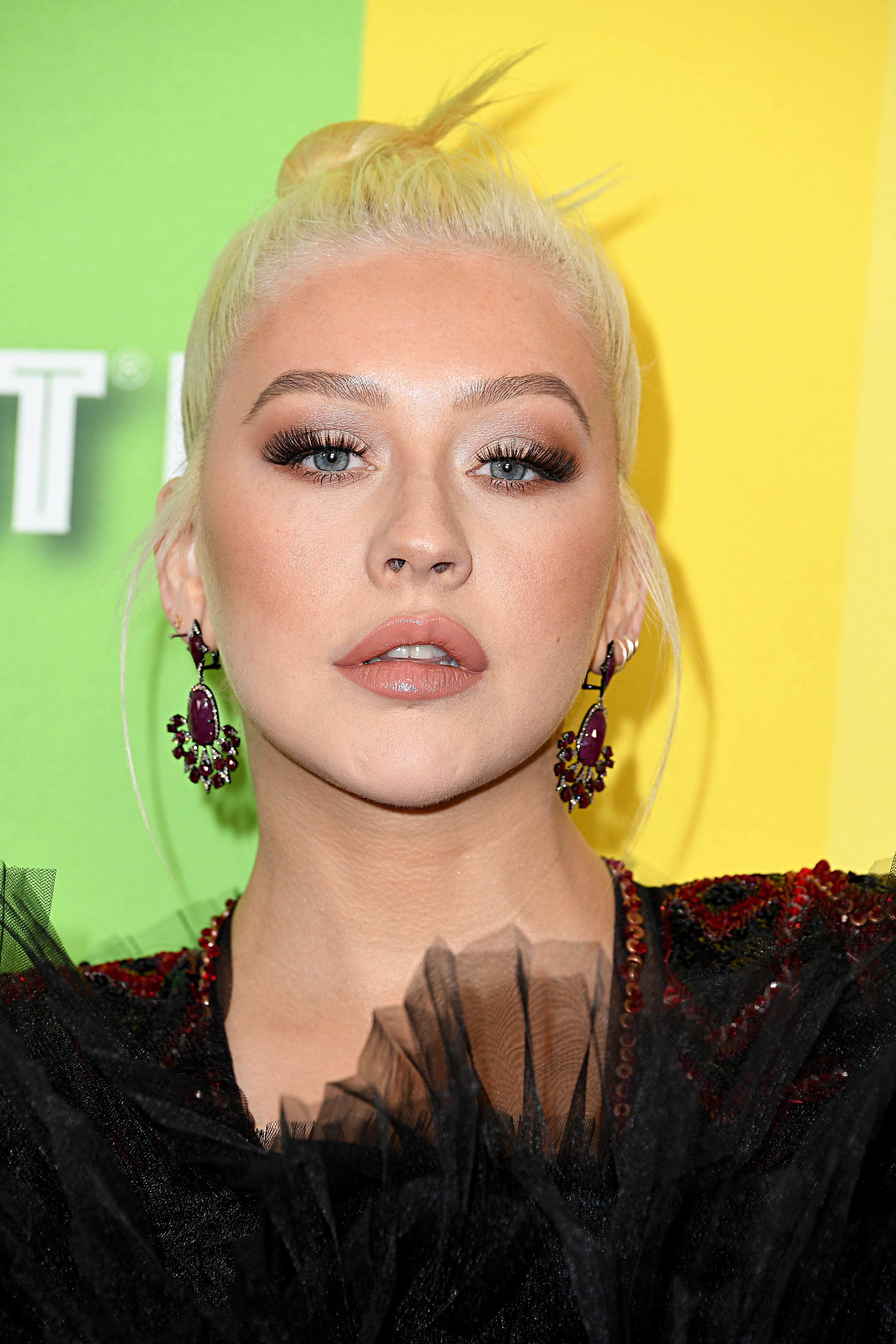 A close-up of Christina Aguilera who is wearing her hair in a high bun