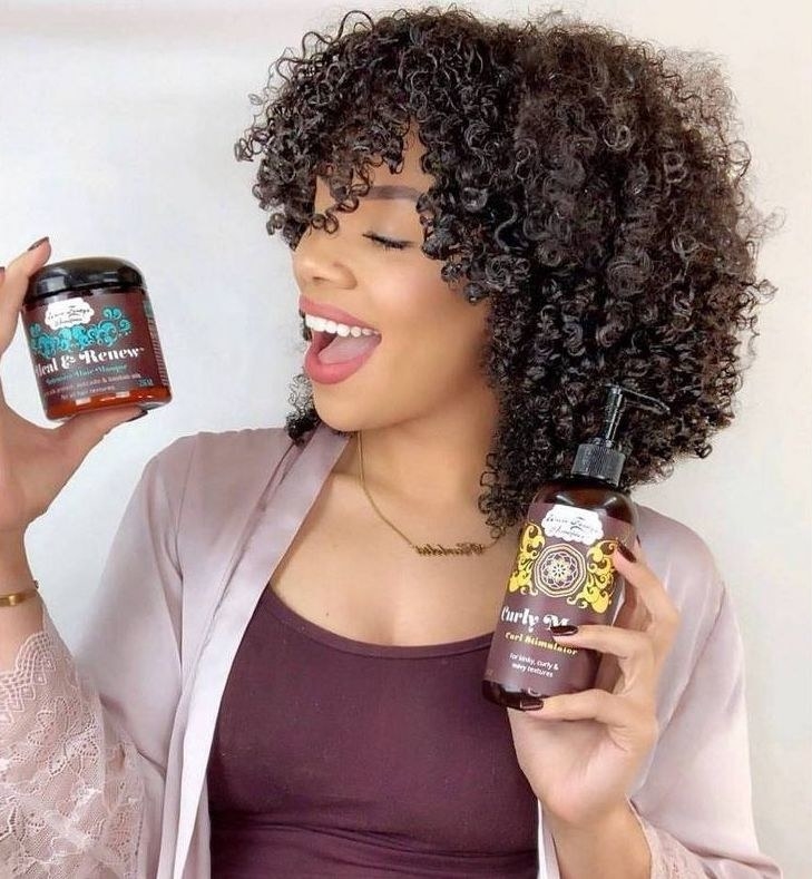 A person holding a jar and a bottle of hair products
