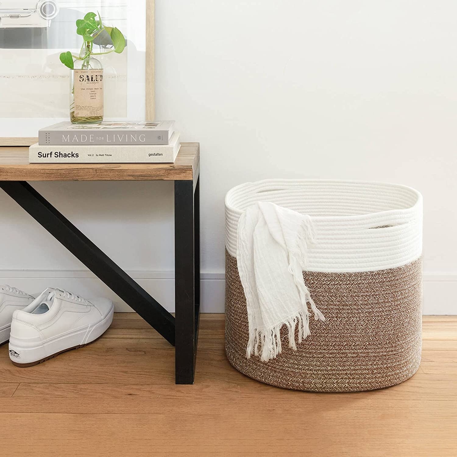 the storage basket on the floor with a blanket hanging half out of it